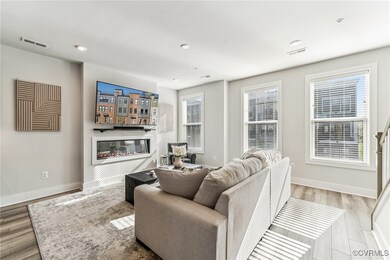 Living area with visible vents, baseboards, and wo