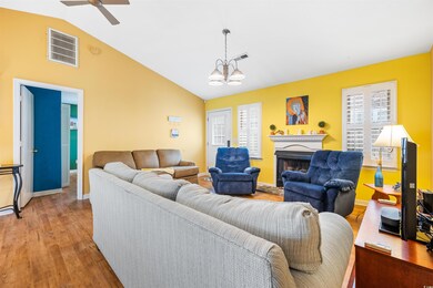 Living room with a chandelier, light hardwood / wo