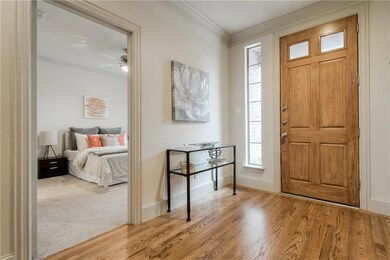 VIEW FROM STAIRS ONTO FRONT DOOR AND GUEST BEDROOM