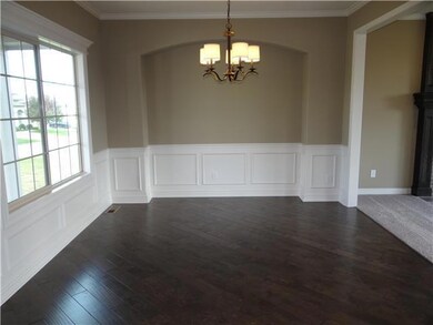 Dining room with warm hard wood flooring.