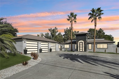 View of front facade with driveway, an outbuilding, a garage, and stucco siding