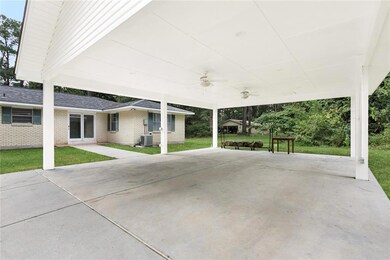 spacious carport in rear with walkway to house
