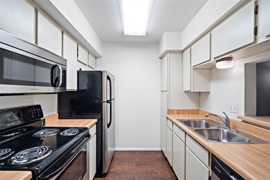 Fully equipped galley kitchen features stainless steel appliances.