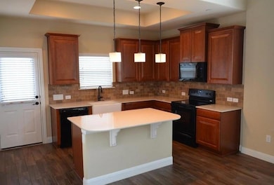 Kitchen featuring black appliances, a sink, dark 