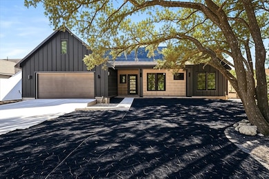 View of front of property featuring board and batten siding, concrete driveway, and an attached garage