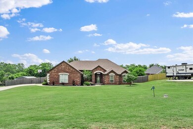 French country inspired facade featuring brick siding and roof with shingles
