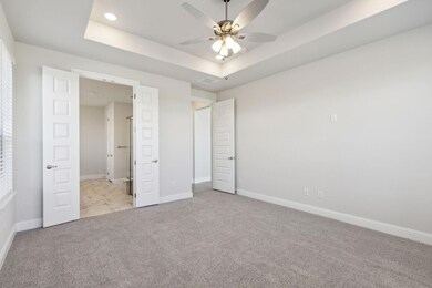 Unfurnished bedroom with light carpet, a raised ceiling, ceiling fan, and recessed lighting