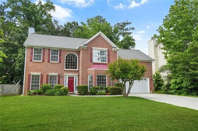 Colonial house featuring driveway, a chimney, brick front, siding, and a shingled roof
