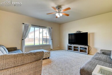 Living room with carpet and a ceiling fan