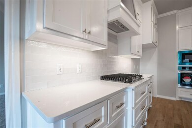 Kitchen with white cabinetry, tasteful backsplash,