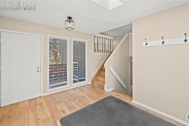 Foyer entrance with a skylight and light wood-type flooring