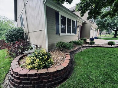 View of side of home featuring a garage and a yard