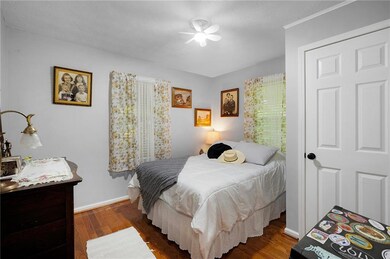 Bedroom featuring wood finished floors, baseboards, and a ceiling fan