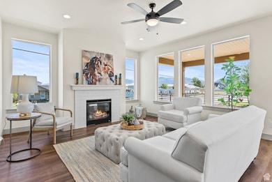 Living room featuring a fireplace, healthy amount of natural light, recessed lighting, dark wood-style flooring, and a ceiling fan