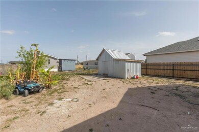 View of yard with fence, a storage unit, and an outdoor structure