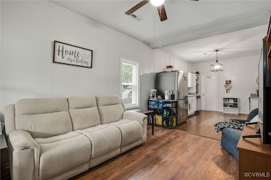 Living room featuring a ceiling fan and dark wood-
