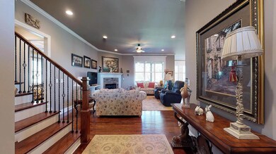 Enjoy an open plan with hardwood floors, crown molding, and wood staircase.