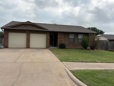 Ranch-style house with a garage, brick siding, concrete driveway, and roof with shingles