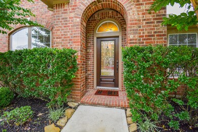 Inviting entry with Mahogany door  and incased elegant glass, covered front door with lush landscape add to the curb appeal.