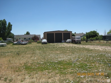 View of yard featuring a detached garage and an outbuilding