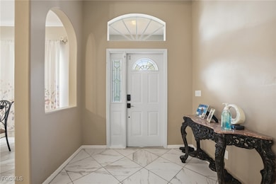 Foyer entrance with light marble finish flooring and arched walkways