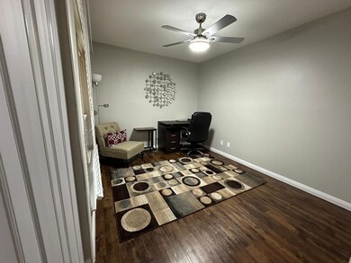 Sitting room featuring ceiling fan and dark hardwood / wood-style floors