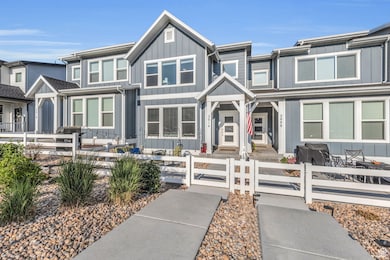View of front of property featuring board and batten siding, a fenced front yard, and a gate