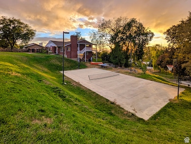 View of basketball court with basketball hoop and a patio
