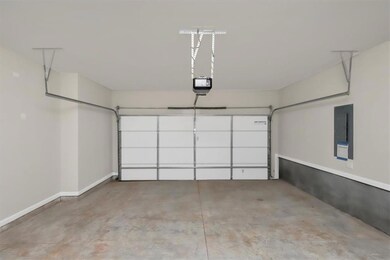 Garage featuring electric panel and a garage door opener