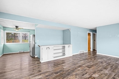 Unfurnished living room with dark wood finished floors and ceiling fan