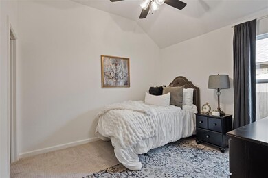 Bedroom featuring lofted ceiling, baseboards, light carpet, and a ceiling fan