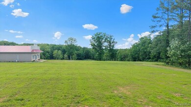 View of green lawn featuring a wooded view