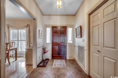 Tiled foyer featuring crown molding and visible ve