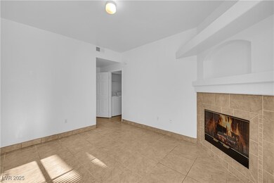 Unfurnished living room with a fireplace, tile patterned floors, and washer / clothes dryer