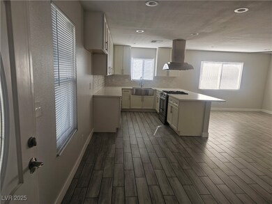 Kitchen with island range hood, a sink, light coun