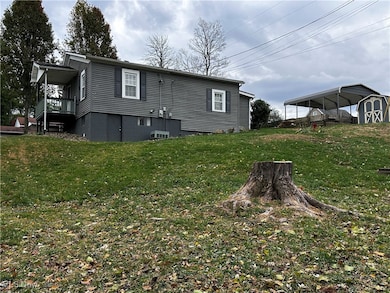 View of side of home with a lawn and a detached carport