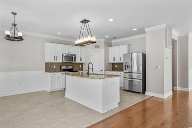 Kitchen with white cabinets, appliances with stain