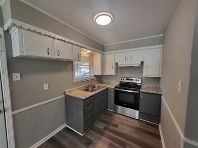 Kitchen featuring electric stove, dark wood-style floors, ornamental molding, white cabinetry, and light countertops