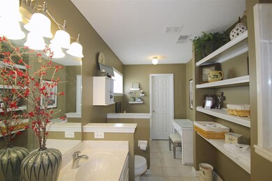 Luxury master bathroom has built-in shelving to fo