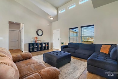 Living area with wood finished floors, plenty of natural light, and a towering ceiling
