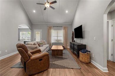 Living room featuring arched walkways, a ceiling fan, high vaulted ceiling, wood finished floors, and recessed lighting