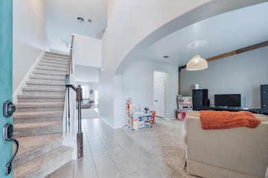 Living room with arched walkways, light tile patt