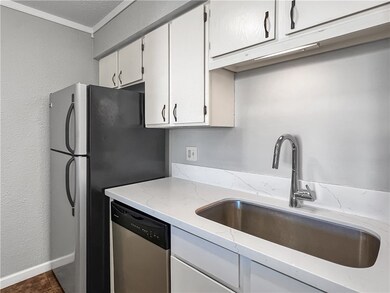 Kitchen with light stone countertops, white cabine