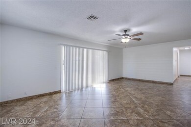 Spare room with visible vents, ceiling fan, a text