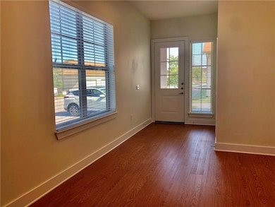 Entryway featuring baseboards and dark wood-type 