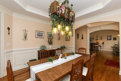 Dining space featuring a wainscoted wall, a raised