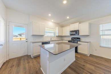 Kitchen featuring white cabinetry, black applianc