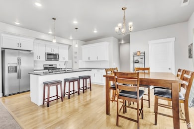 Dining space with recessed lighting, light wood-style flooring, and a chandelier