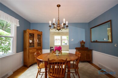 Formal dining room with hardwood floors, connects