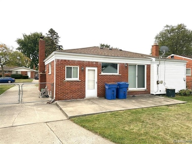 Back of property with a chimney, brick siding, a patio, and a shingled roof